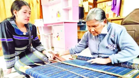 Nghệ nhân Ưu tú K'Glòng bên khung dệt thổ cẩm Cơ Ho